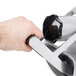 A hand holding a metal Vollrath #12 Slicer attachment.