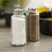 Two Tablecraft flat paneled salt and pepper shakers on a table.
