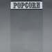 A clear plastic panel with "popcorn" in white and black text.
