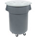 A grey plastic trash can with wheels and a white lid.