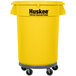 A yellow Continental Huskee round trash can with a dolly and lid.