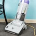 A ProTeam ProGen upright vacuum cleaner sitting on a chair.