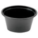 A Newspring black oval plastic souffle cup.