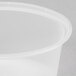 A close-up of a clear plastic Newspring oval souffle cup with a lid.
