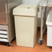 A beige Continental Swingline trash can with a lid.