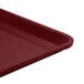 A close-up of a red Cambro dietary tray with a black bottom.