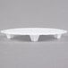 A white round Wilton cake separator plate with scalloped edges and two legs.
