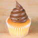 A cupcake with brown frosting piped on top using an Ateco 802 Plain Piping Tip.