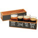 A Cal-Mil Madera wooden crate with four glasses of beer in it.