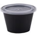 A black oval plastic souffle container with a clear lid.