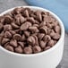 A bowl of HERSHEY'S Special Dark chocolate chips on a blue cloth.