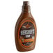 A brown plastic bottle of HERSHEY'S Caramel Syrup with a label.