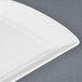 A close up of a CAC Paris white china fashion platter with a small rim.