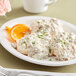 A plate of biscuits topped with Vanee Old Fashioned Biscuit Gravy served with orange slices.