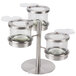 A stainless steel tiered jar display for 3 jars with hinged lids on a metal stand.