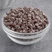 A bowl of HERSHEY'S Mini Semi-Sweet Chocolate Chips on a table.