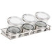 A Cal-Mil stainless steel tray holding three glass containers with notched lids.