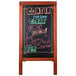 An American Metalcraft mahogany A-frame sign board with chalk writing on it.