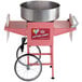 A pink cotton candy machine with a large steel bowl on a cart.