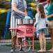 A man making cotton candy with a Carnival King cotton candy cart.