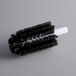 A close-up of a black and white circular Noble Products glass washer brush.
