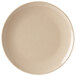 A close-up of a beige bamboo melamine plate with a speckled surface.