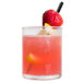 A Libbey votive shot glass filled with a strawberry cocktail with a straw and a slice of fruit.