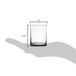 A hand holding a Libbey votive shot glass with a white liquid in it.