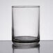 A clear glass Libbey votive shot glass on a table with a white background.