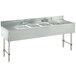 An Advance Tabco stainless steel underbar sink with four compartments and two drainboards.