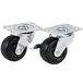 A pair of metal casters with black rubber wheels.