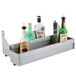 A stainless steel shelf with a double tier of liquor bottles.
