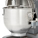 An Avantco  stainless steel mixing bowl attached to a large metal mixer.
