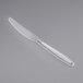 A Visions clear plastic knife on a gray background.