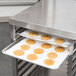 A Lakeside stainless steel work table with sheet pan storage holding a tray of cookies.