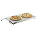 A Vollrath heated shelf with two pizzas on plates.