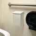 A white plastic Rochester Midland sanitary napkin receptacle with a lid.