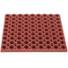 A red Notrax Tek-Tough rubber mat with holes.