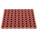 A red rubber square mat with holes.