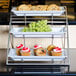 An American Metalcraft three-tier chrome display stand with cupcakes, muffins, and cookies.