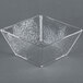 A clear square styrene bowl with a textured surface.