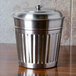 A close-up of a silver American Metalcraft mini stainless steel trash can lid.