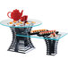 A black metal Cal-Mil elevation riser holding a table with sushi and a red teapot.