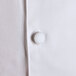 A close up of a white Chef Revival chef coat with a black button.