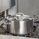 A large silver Vollrath casserole pan with a lid on a stove.