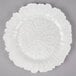 A white Charge It by Jay glass charger plate with a scalloped edge.