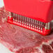 A Chef Master meat tenderizer with metal tips being used on a piece of meat.