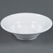 An American Metalcraft white stoneware bowl on a gray surface.