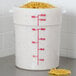 A large white Cambro food storage container with measurements on it, filled with noodles.