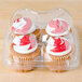 A clear plastic InnoPak container holding four cupcakes with red and white icing.